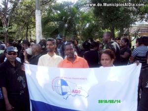 Profesores sostienen banderola de la Asociación Dominicana de Profesores en vigilia realizada en el parque municipal de Haina. 