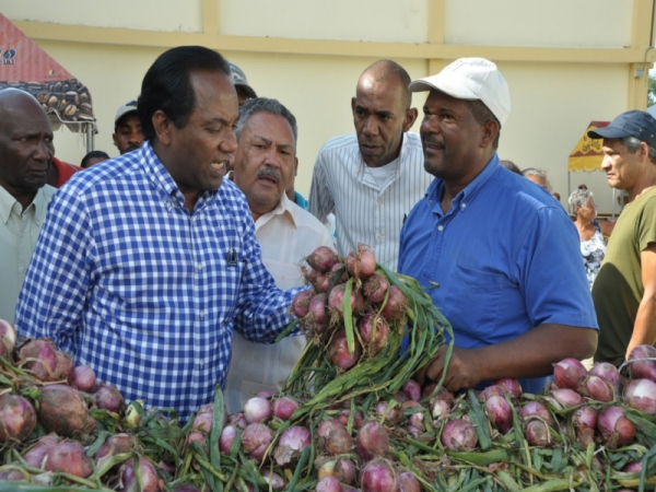 Jorge Zorrilla Ozuna conversa con uno de los productores de cebolla de Ocoa. 