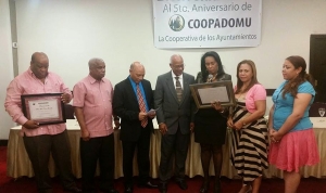 Momentos en que Andrés Julio Ricardo recibe su placa de reconocimiento por parte de Coopadomu.