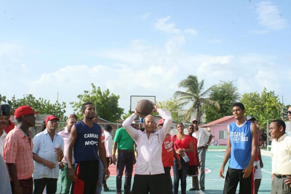 Gonzalez Espinosa lanza al canasto la bola de honor para dejar inaugurada la cancha de baloncesto en La Peñuela del municipio Cabral, provincia Barahona.