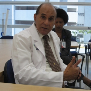 El director del instituto doctor Francisco Monegro Santos, egresado de la UASD, explicó los objetivos del centro de salud, donde la clase más desposeída del país, tiene prioridad de atención en el INCART. Detrás la periodista Emilia Santos