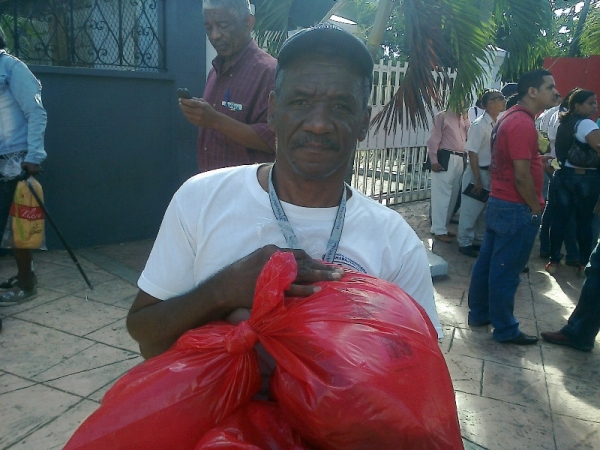 Un hombre carga las bolsas conteniendo productos alimenticios y de le época durante el reparto navideño que realizó la fundación Jaoquin Balaguer