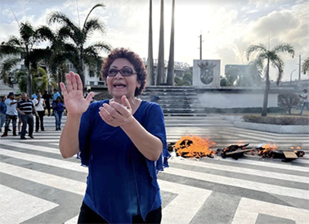 María Teresa Cabrera agita sus manos al momento de la quema del &quot;Judas de la corrupción&quot; en la plazoleta La Trinitaria, junto a dirigentes del Frente Amplio, que se ven al fondo.