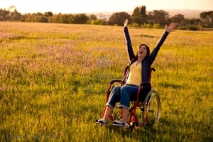 Mujer con discapacidad en un prado verde.