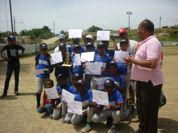 El equipo de Juan de Herrera muestra su trofeo de campeón y pergaminos junto a Edgar Ramírez, director de Deportes de San Juan.