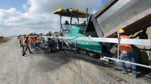 Obreros del Ministerio de Obras Públicas en plena ejecución de asfaltado de una carretera en República Dominicana.