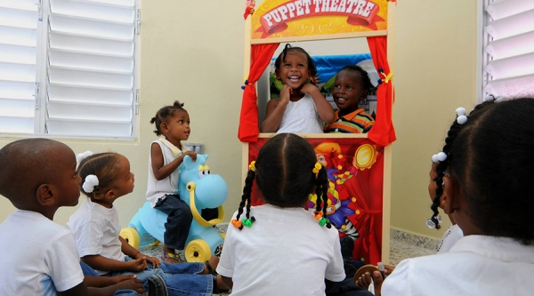 Niños y niñas juegan con el teatrino de títeres en la nueva estancia infantil de San Cristobal entregada por la Presidencia de la República.