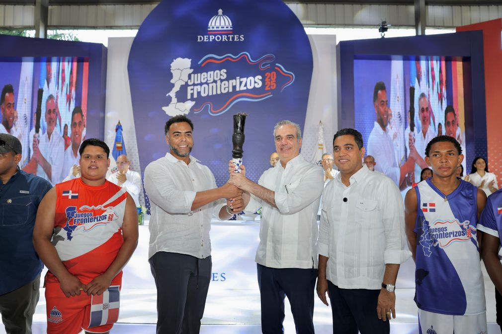 El exjugador de grandes ligas, Nelson Cruz, entrega la antorcha al presidente Luis Abinader y Kelvin Cruz.