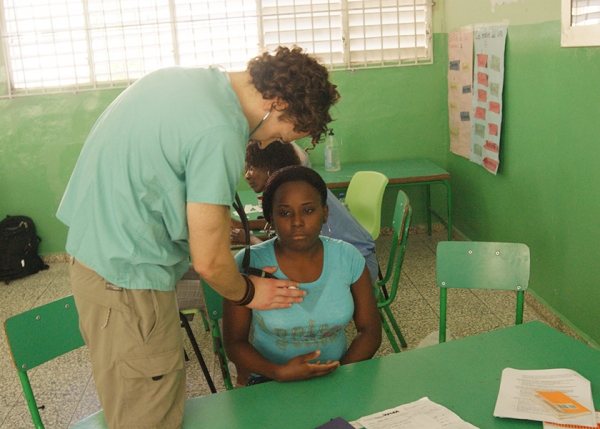 Uno de los médicos de la Universidad de Virginia de Estados Unidos, haciendo un chequeo médico a una ciudadana en Santo Domingo Norte.