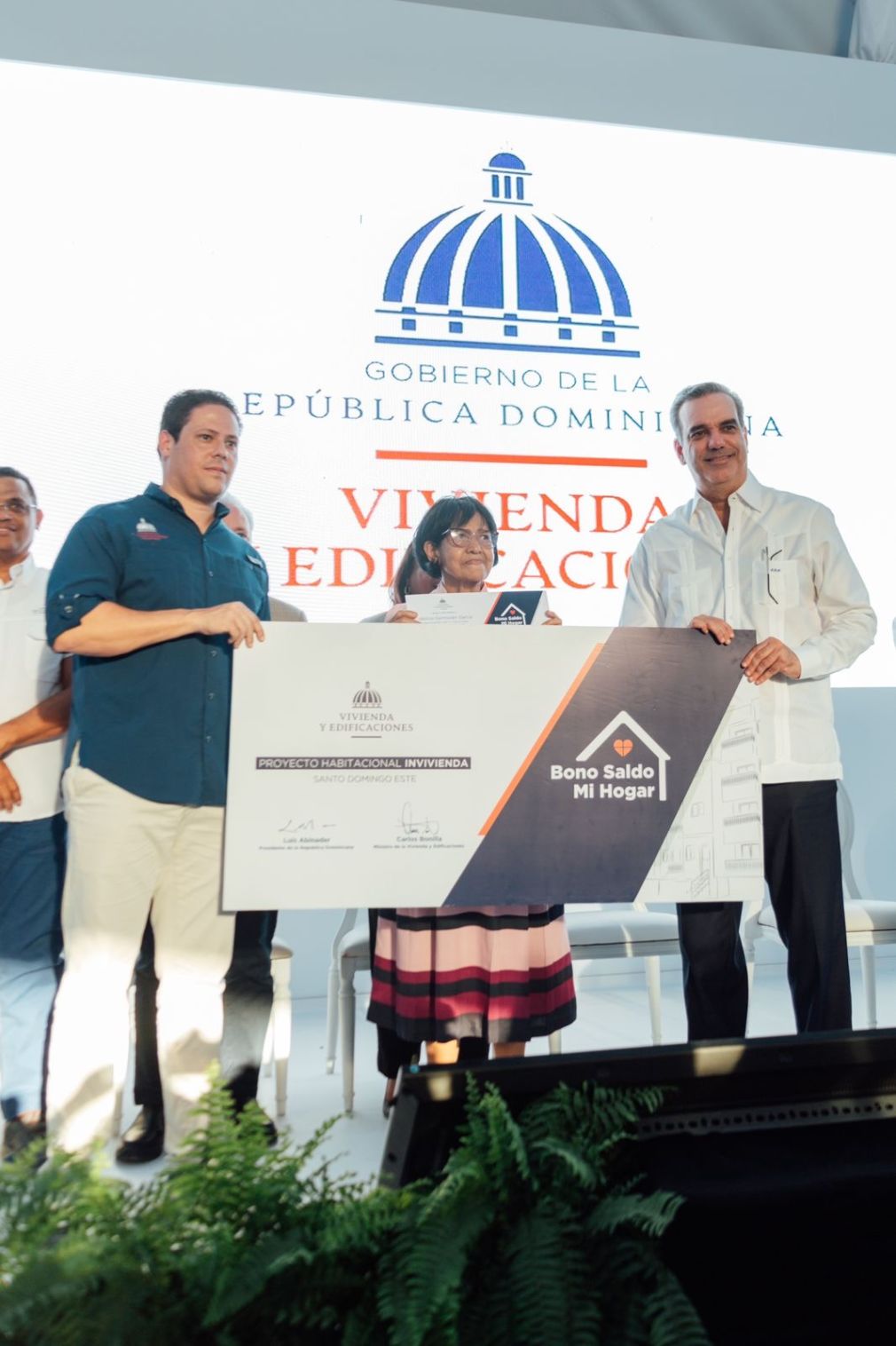 Ministro de la Vivienda y Edificaciones, Carlos Bonilla y el Presidente de la República, Luis Abinader, haciendo entrega de un bono.