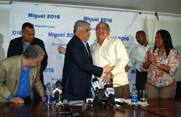 Miguel Vargas y Rutinel se confunden en una abrazo, flanqueados por César Cabrera y Altagracita Tavárez.