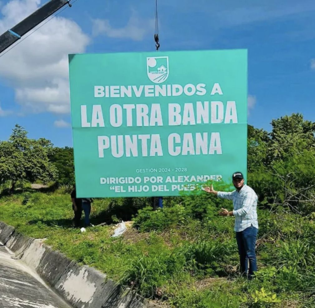 El director distrital Alexander Rodríguez durante la colocación del letrero de bienvenida en la entrada de La Otra Banda.