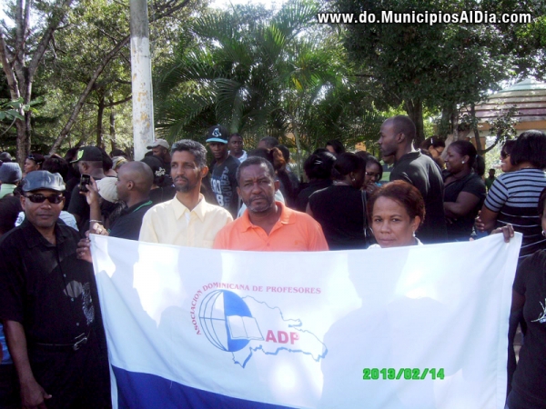 Profesores sostienen banderola de la Asociación Dominicana de Profesores en vigilia realizada en el parque municipal de Haina. 