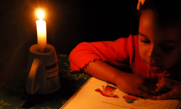 Esta niña recurre a la lectura de cuentos para dejar correr las horas oscuras y de calor que le esperan a los dominicanos esta noche.