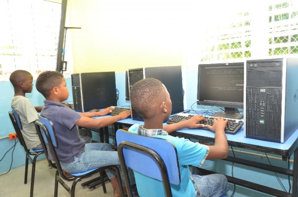  Niños de Batey Cuchilla del municipio de Tamayo acceden a las computadoras en la sala digital inaugurada por el Indotel y Visión Mundial. 