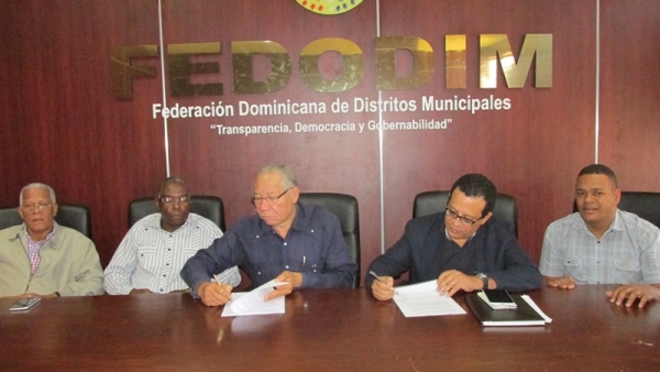 El doctor Pedro Richardson y César Peña, firman convenio de cooperación en las oficinas de FEDODIM. Observan Máximo Soriano, Héctor Bienvenido Ricardo y Alex Aquino.