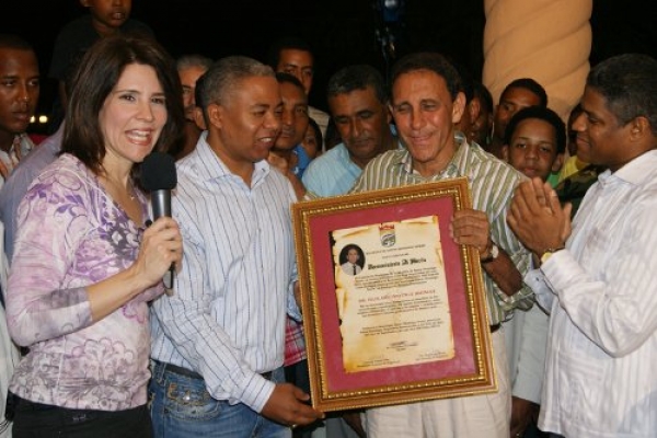Dr. Cruz Jiminian recibe pergamino de las manos del alcalde Francisco Fernández.