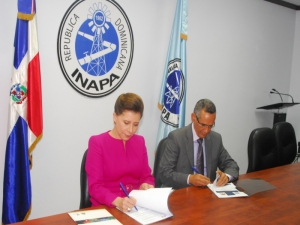 Alberto Holguín y Melba Segura de Grullón firman el acuerdo.  
