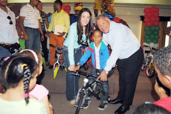 Gilberto Serulle, alcalde del Ayuntamiento de Santiago entrega una bicicleta a un niño por motivo del Día de los Santos Reyes Magos.