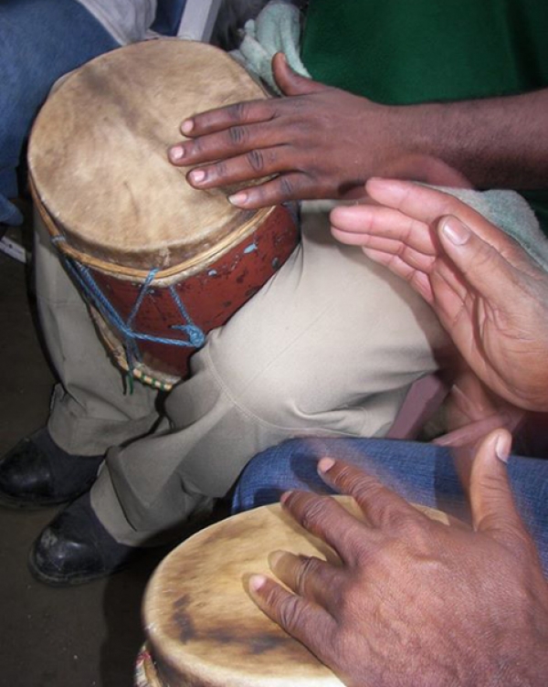 Manos tocando dos de los tres tambores de la Sarandunga. 