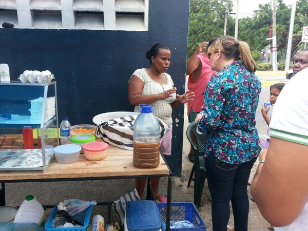 La precandidata a diputada Milagros Ricardo, conversa con una vendedora de comida en las proximidades de la avenida Duarte en la Capital de Santo Domingo.