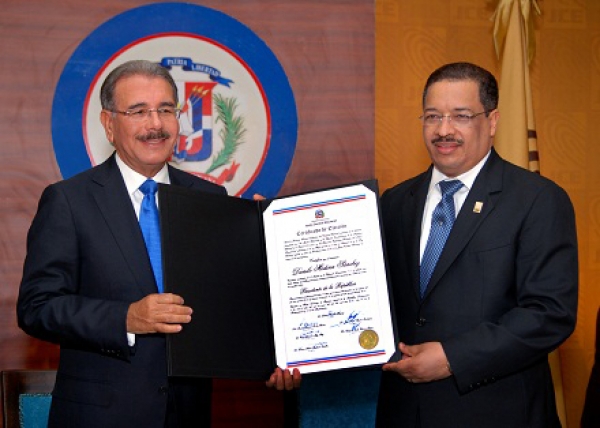 Danilo Mediona recibe de manos del presidente de la JCE, Roberto Rosario el certificado que lo acredita como presidente de la república.