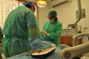 La Dra. Bellamire Alevante junto a otro doctor preparan a un paciente para ser intervenido con un implante.