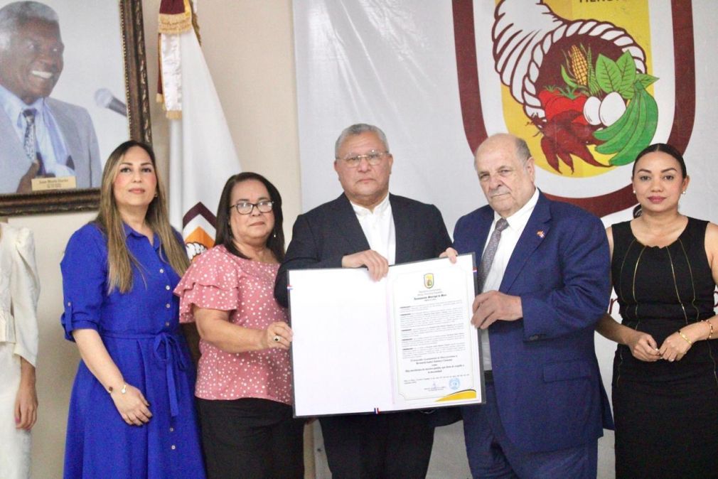 El alcalde de Moca, Miguel Guarocuya Cabral, entrega la proclama municipal que declara a Bernarda Jiménez Clemente como Hija Predilecta de Moca.