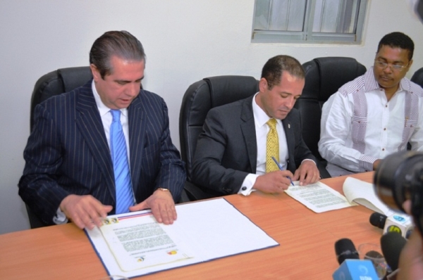 Francisco Javier García, Ministro de Turismo y Juan de los Santos, presidente de FEDOMU en el momento que firman el acuerdo, a su lado Víctor D’ Aza, director ejecutivo de FEDOMU. 