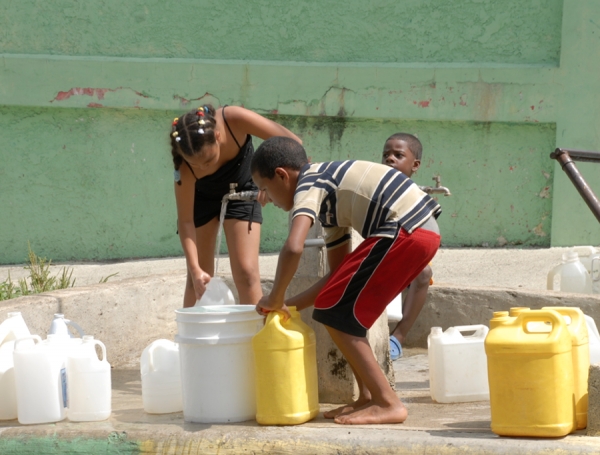 Niños y niñas son enviados por las familias dominicanas a buscar agua donque quiera que pueda aparecer un chorrito para los quehaceres familiares.