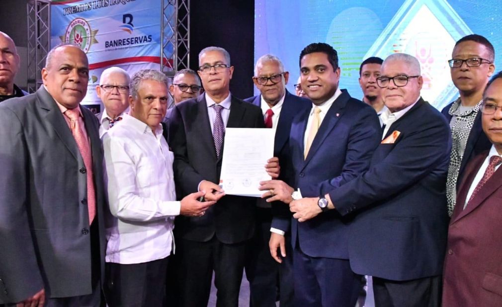 El ministro de Deportes, Kelvin Cruz, muestra la cotización a los cronistas deportivos de Santiago para remozar la casa club de la ACDS.