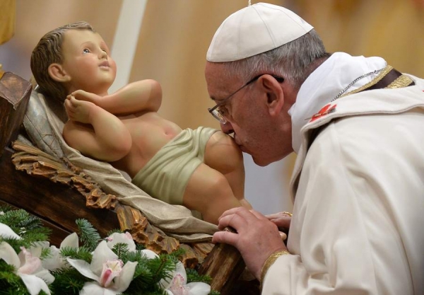 El Papa Francisco besa una figura del Niño Jesús, durante la tradicional ceremonia de la Misa de Gallo en El Vaticano.