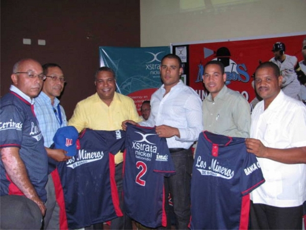 Los ejecutivos de la empresa Falcondo Xstrata Níke, Leandro Santos y Ángelo de La Cruz, entregan el juego de uniformes a los directivos de los Mineros de Bonao y al presidente de la liga de verano Tito Pereyra.