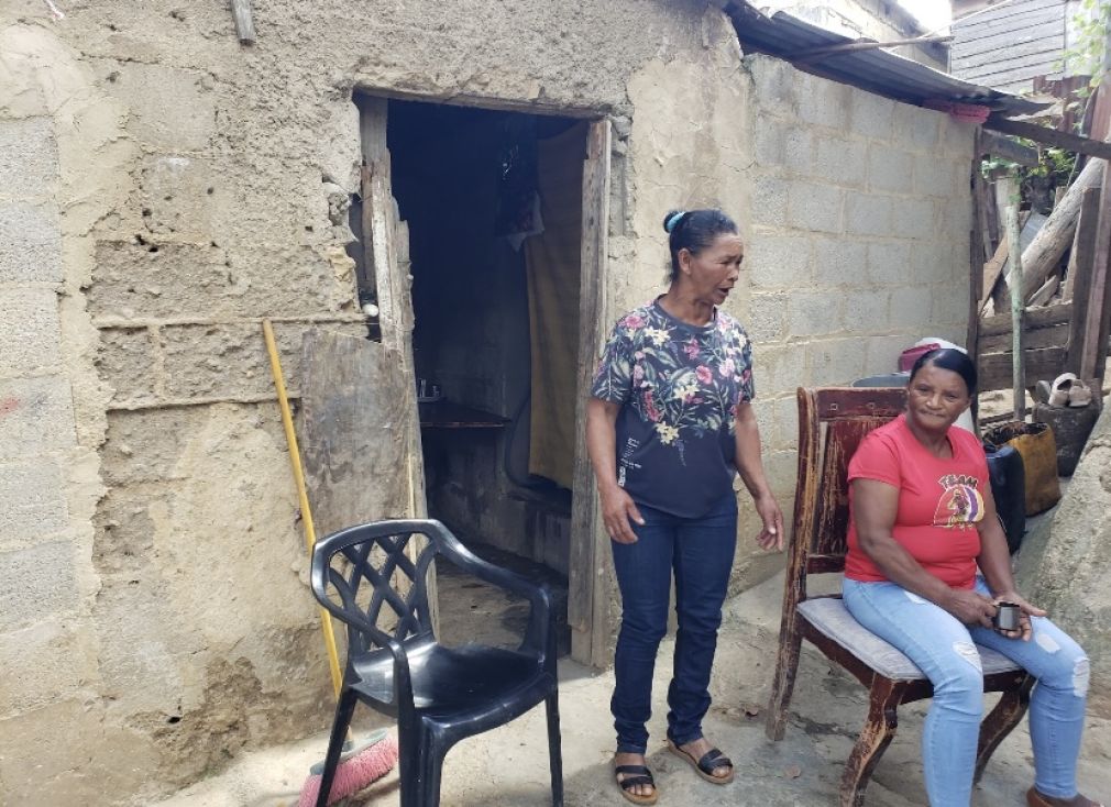 Isidra Delgado de los Santos (de pie) mientras conversa con una vecina.