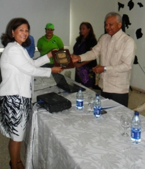 La Biológa Marina Tejera, rcibe la placa de reconocimiento de manos del director de CODOPESCA.