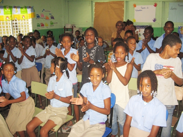 Niños aplauden en el momento que anuncian que recibirían utiles escolares gratis por parte de la Liga Municipal Dominicana.