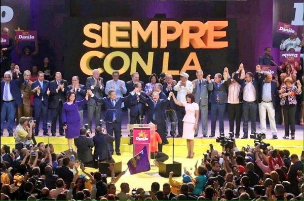 Danilo Medina y Leonel Fernández, levantan sus manos junto a sus esposas, como señal del triunfo del PLD en las próximas elecciones.