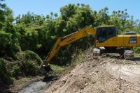 Retro excavadora realiza limpieza de drenaje en el Distrito Municipal Proyecto C2.