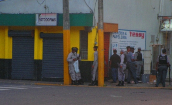 Agentes policiales se protegen de las piedras lanzadas por los manifestantes.