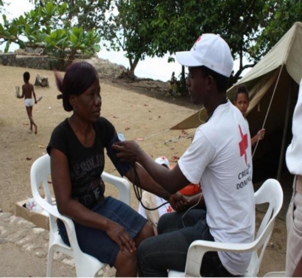 Voluntario de la Cruz Roja dando asistencia a una vacacionista.