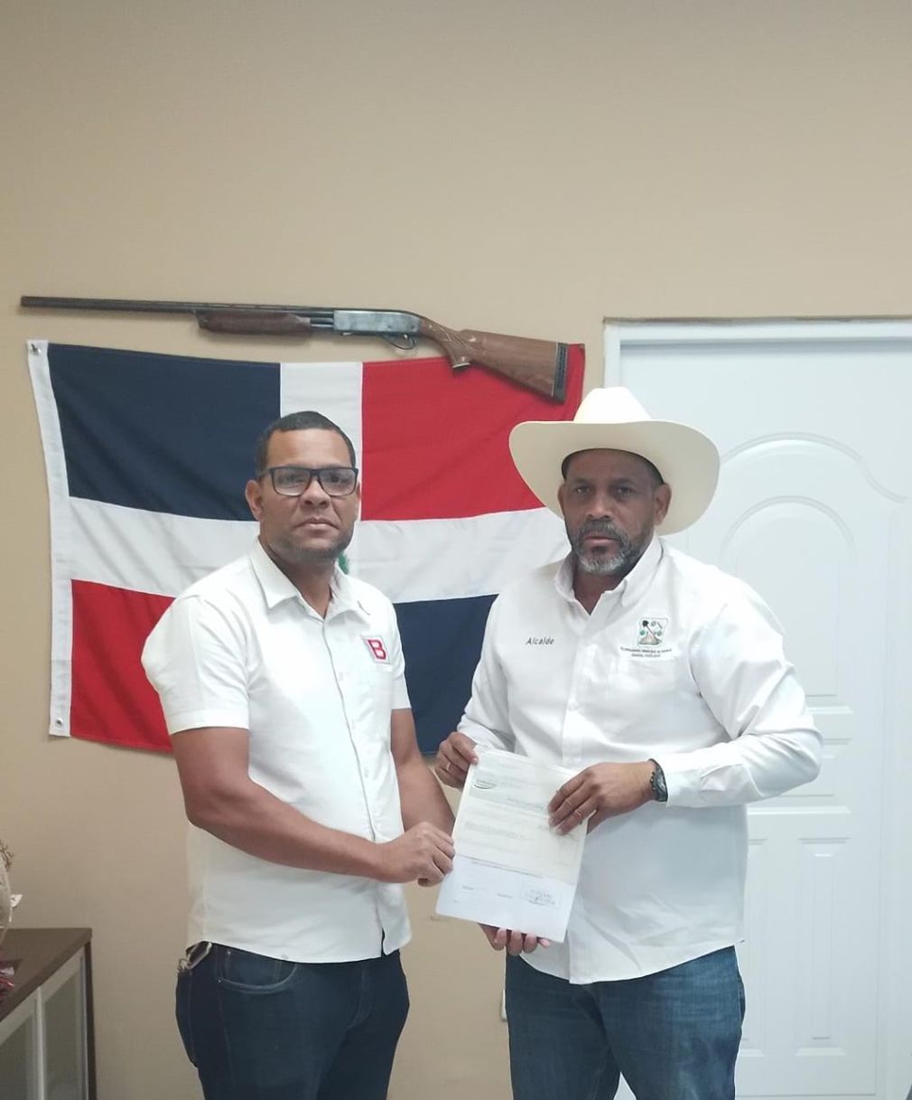 El alcalde Santiago Riverón, entregando el aporte económico a Julio Fabian, padre de dos niños con Neurofibromatosis y Leucemia.