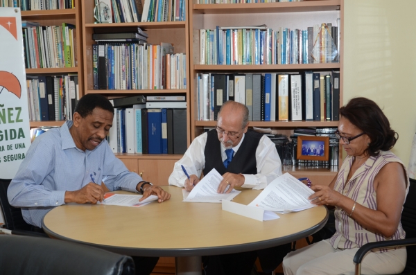 El director nacional de Visión Mundial República Dominicana, Claudio Doñé Castillo, y la directora de la Fundación Leer Es Divertido, Luz María Franco Casado mientras firmaban el acuerdo.