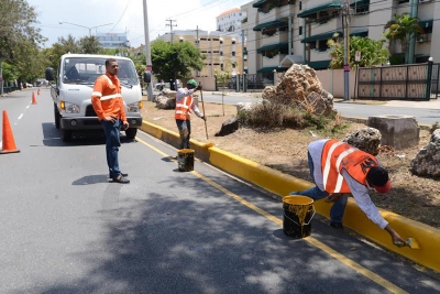 Empleados del Ministerio de Obras Públicas y Comunicaciones en fase final de limpieza de la avenida Nuñez de Cáceres en Santo Domingo.