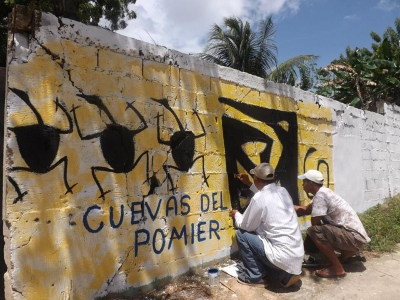 Artistas pintan murales alusivos a las cuevas del Pomier en San Cristobal.