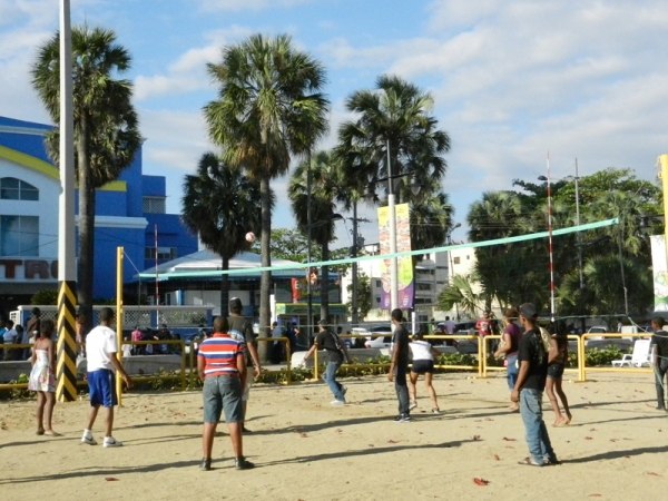 Jóvenes juegan voleibol en la Plaza Guibia del Malecón de Santo Domingo.