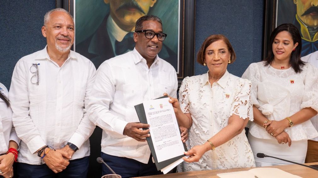 Al centro el director ejecutivo del IDOPPRIL Agustín Burgos y la alcaldesa Amparo Custodio, firmaron el acuerdo interinstitucional.
