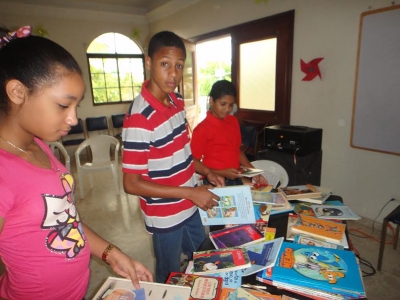 Niños y niñas escogen cual libro prefieren leer durante el trayecto de las Olimpiadas de Lecturas interbarrial de Santo Domingo Este.