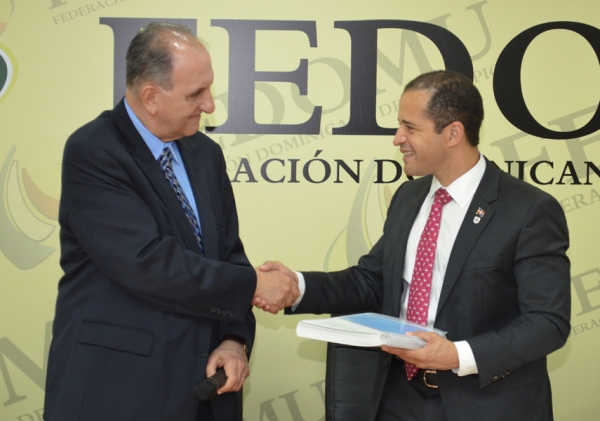 Momentos en que el señor Pablo Tactuk entrega los datos impresos contenidos en el Sistema de Informaciones de Estadística Territorial a Juan de los Santos, presidente de la Federación Dominicana de Municipios.