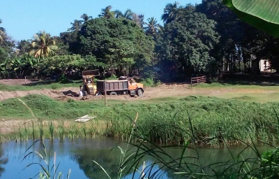 Camiones autorizados por las autoridades de medio ambiente local extraen arenas de los humedales del río Yásica.