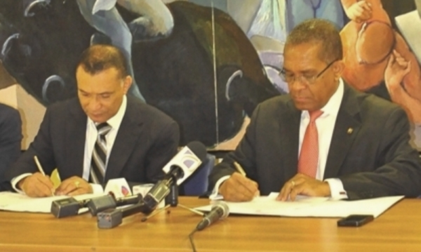 firmando el acuerdo Mateo Aquino Febrillet y Alfonso Radhamés Valenzuela